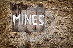Wooden weathered warning sign for mines photo
