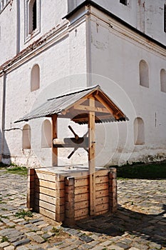 Wooden well. Blockhouse of a well made of bars, in the courtyard of the monastery.