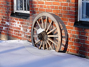 Wooden wheel on the background of an old brick wall