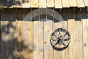 Wooden wheel on the wall of the barn