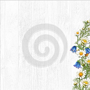 Wooden white background with a bouquet of daisies and bells. copy space