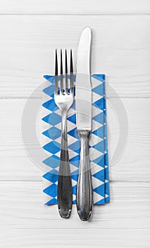 Wooden white background for a menu card with cutlery in blue whi