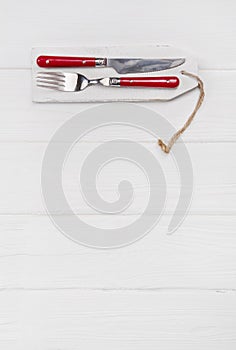 Wooden white background for a menu card with cutlery in red whit