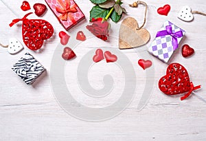 Wooden white background with red hearts, gifts and roses