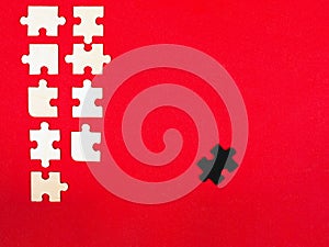 Wooden white and black puzzles on a red background outcast antisocial leader differ from others children educational toy