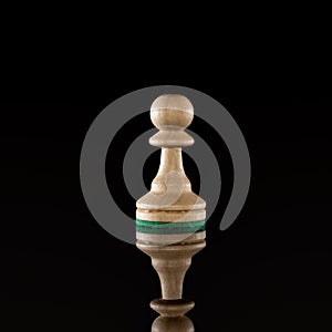 Wooden white chess pawn isolated at dark background