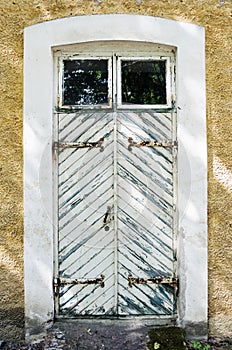 Wooden white door with wrought-iron hinges