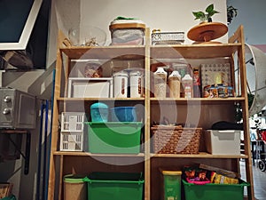 Wooden and white kitchen cabinet with food ingredients. Low angle view of drawers with