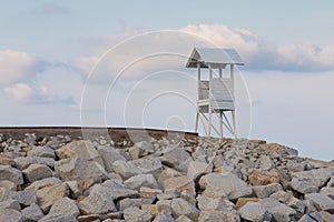 Wooden White lifeguard over rock coastline