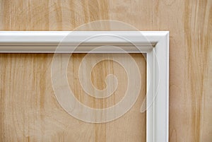 Wooden white molding on plywood background. Wood door manufacturing process. Furniture manufacture photo