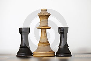 Wooden white queen and black rooks chess pieces