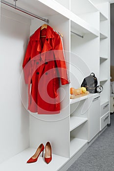 Wooden white wardrobe for womenâ€™s clothes, open doors, decor, bag, hangers, silk dresses in a bright room, concept, flowers