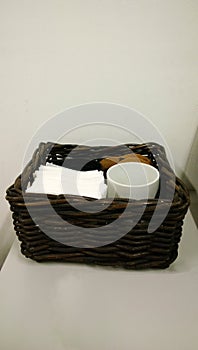 Wooden wicker basket with napkins and cups for a coffee break in an office