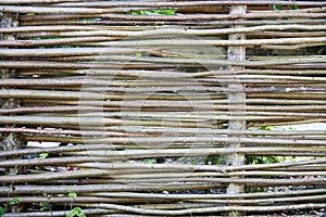 Wooden wicker fence made of sticks in the countryside