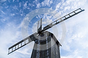 Wooden windmill from below against blue sky