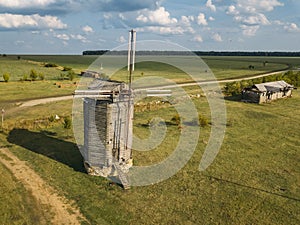 Wooden windmill on rural landscape in summer sunny day, aerial view