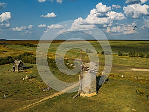 Wooden windmill on rural landscape in sunny summer day, aerial view