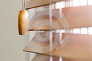 Wooden window blinds partially closed with bright light