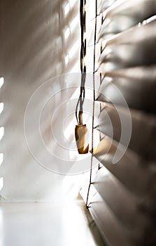 Wooden window blinds partially closed with bright light