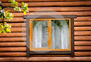 Wooden window on facade of house made of wooden beams. Pros and cons of wooden windows concept