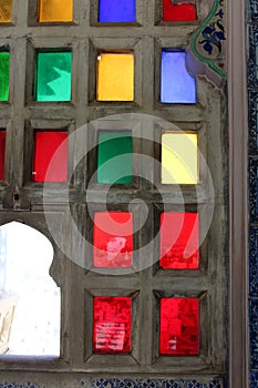 A wooden window with fitted glasses of red, green, yellow and blue color