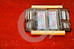 Wooden window on the red wall.