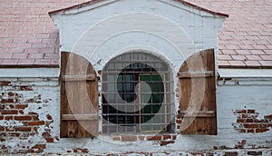 Wooden window sashes with metal bars. An old historic building with white walls. Astrakhan photo