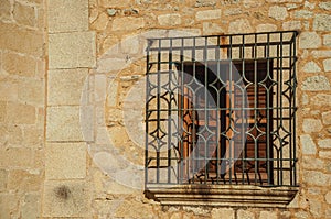 Wooden window with wrought iron grid at Caceres