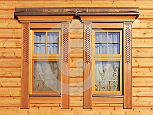 Wooden windows in paneled house wall