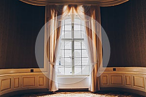 Wooden windows with vintage curtains and square moldings on a sunny day. beige satin curtains. interior of an empty room with