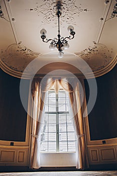 Wooden windows with vintage curtains and square moldings on a sunny day. beige satin curtains. interior of an empty room with