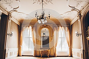 Wooden windows with vintage curtains and square moldings on a sunny day. beige satin curtains. interior of an empty room with