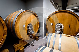 Wooden wine barrels stacked in modern winery cellar in Spain