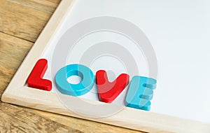 Wooden word LOVE on the corner of White board