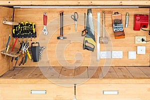 Wooden workbench at workshop. Lot of different tools for diy and repair works. Wood desk for product display. Copyspace. Labour da