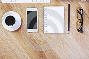 Wooden workplace with smartphone and notepad