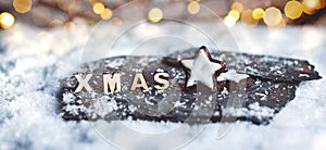 Wooden XMAS letters in a snow scene with blurred lights