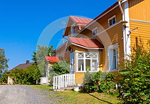 Wooden yellow house with red roof in Scandinavian style