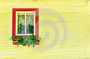 Wooden yellow hut and window with flowers
