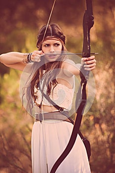 Woodland hunter woman with bow and arrow