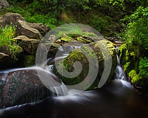 Woodland scene slow moving river stream in the Derbyshire Peak District National Park. Shot with slow shutter speed.