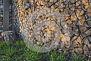 A woodpile of dry birch wood in the backyard of the house close-up. Pile firewood prepared for fireplace