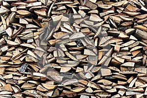 Woodpile lies in a heap, chopped for burning in a furnace. Finely chopped and stacked firewood, background. Laid dry