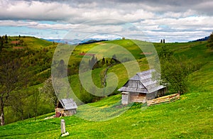 Woodshed on a grassy hillside on a cloudy day