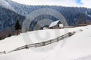 Woodshed on the hillside in winter mountains