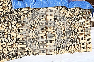WOODSHED with pieces of wood piled up for the winter and snow