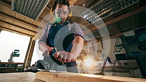 Woodsman is processing wood with a jigsaw