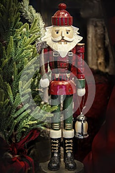 Woodsman wooden Christmas nutcracker  with ax and latern surrounded by trees and wood and red plaid