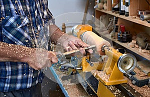 The woodturner work. Man`s arms with cutter in action.