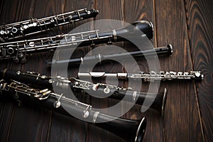 Woodwind instruments lie on a wooden surface